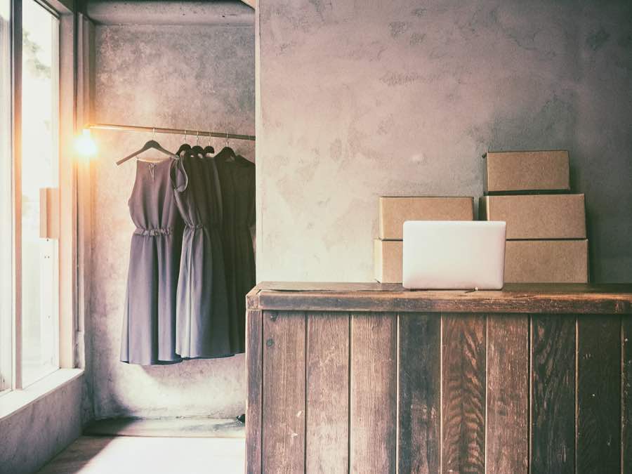 Trastienda de una tienda online de moda con un portátil listo para gestionar pedidos